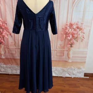 Three-quarter sleeves. Full circle skirt, T-length with 2 layers. Front slit with small pleats. Theron's Fashion and Bridal Boutique